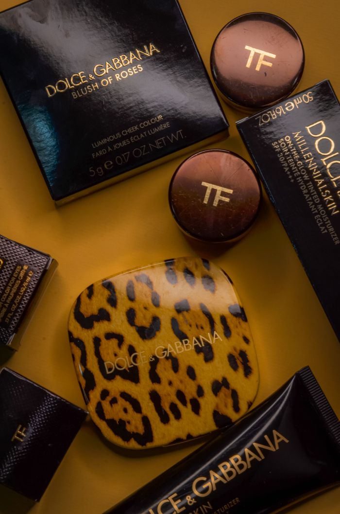 Services High-end makeup products arranged artfully on a bold yellow backdrop.