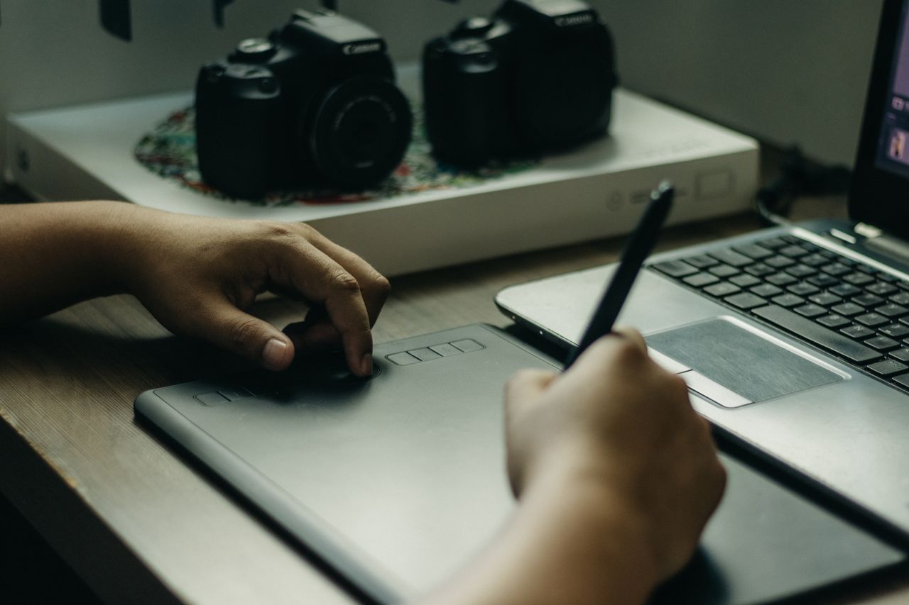 The Art of Drawing Readers In: Your attractive post title goes here A cozy setup featuring a graphic tablet, pen, and laptop for digital art creation.